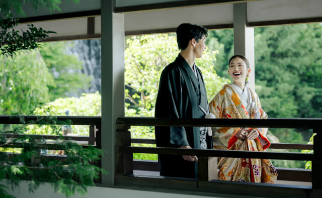 庭園を望む縁側で笑い合う和装の新郎新婦
