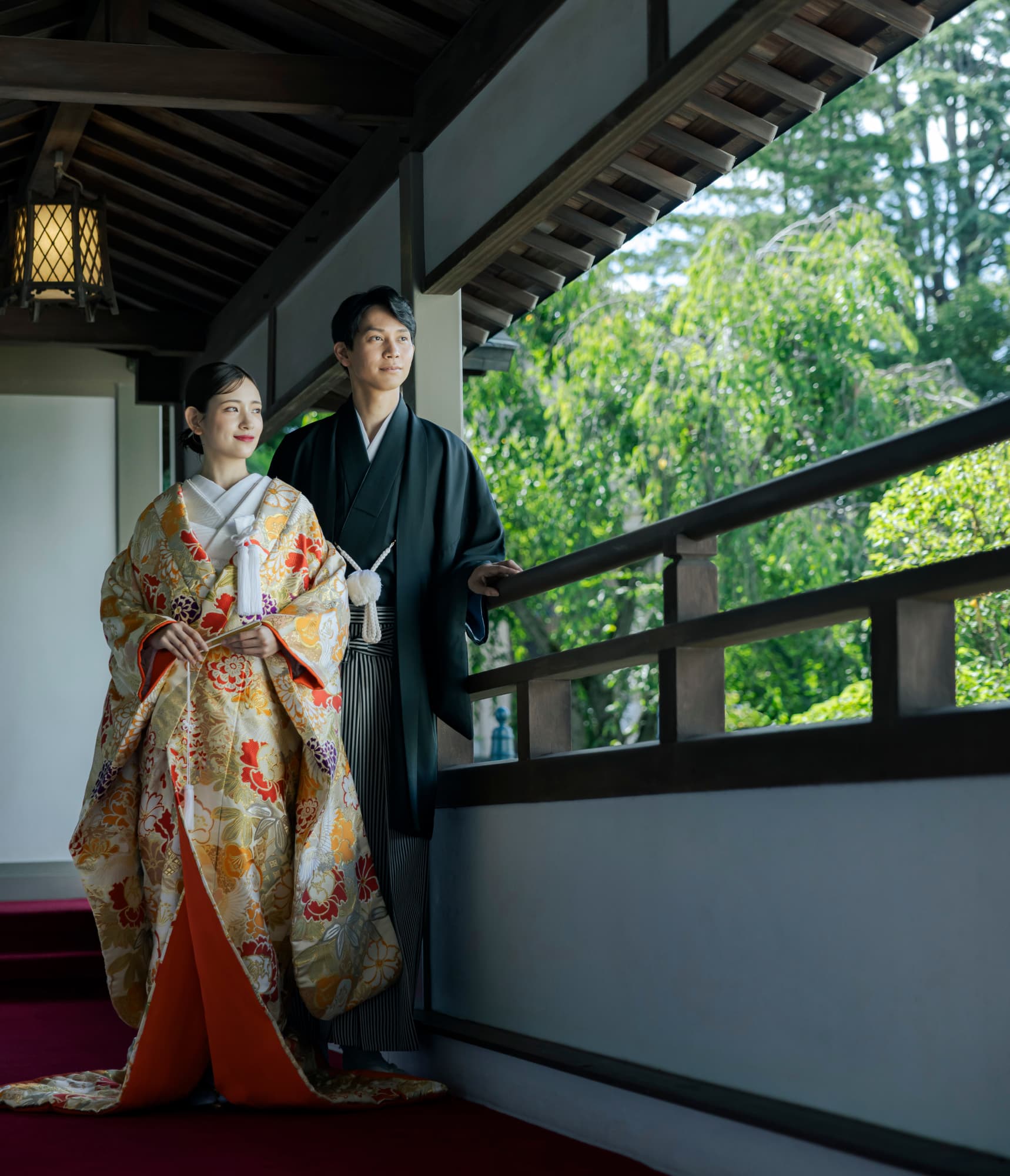 パイプオルガンが並ぶ教会の祭壇でブーケを持つ花嫁と新郎